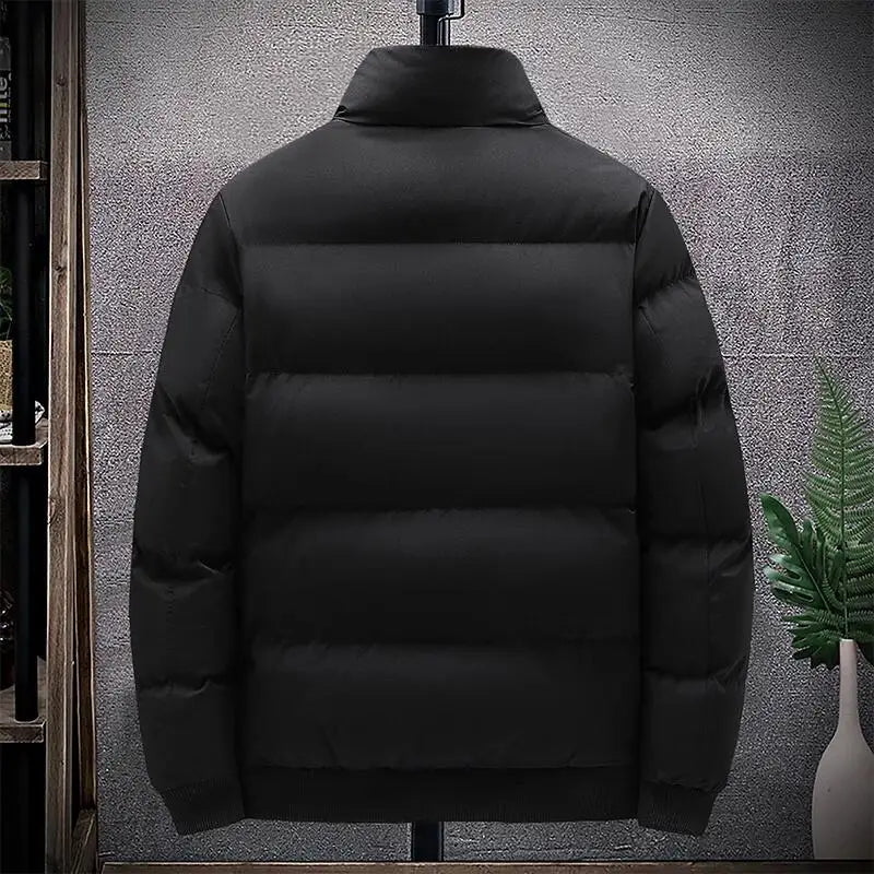 Black puffer jacket on a mannequin against a textured wall.